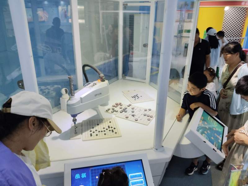 图为游客与下棋机器人互动